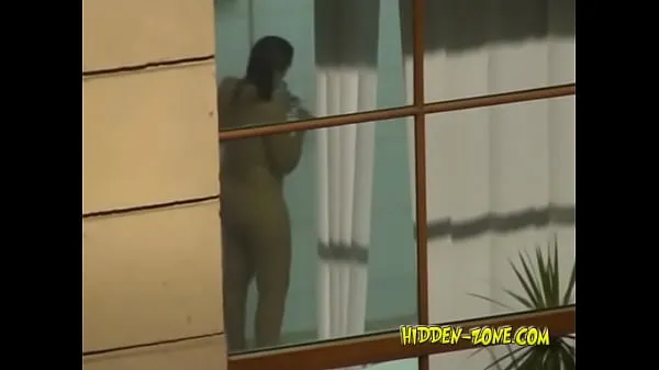따뜻한 클립A girl washes in the shower, and we see her through the window 표시합니다
